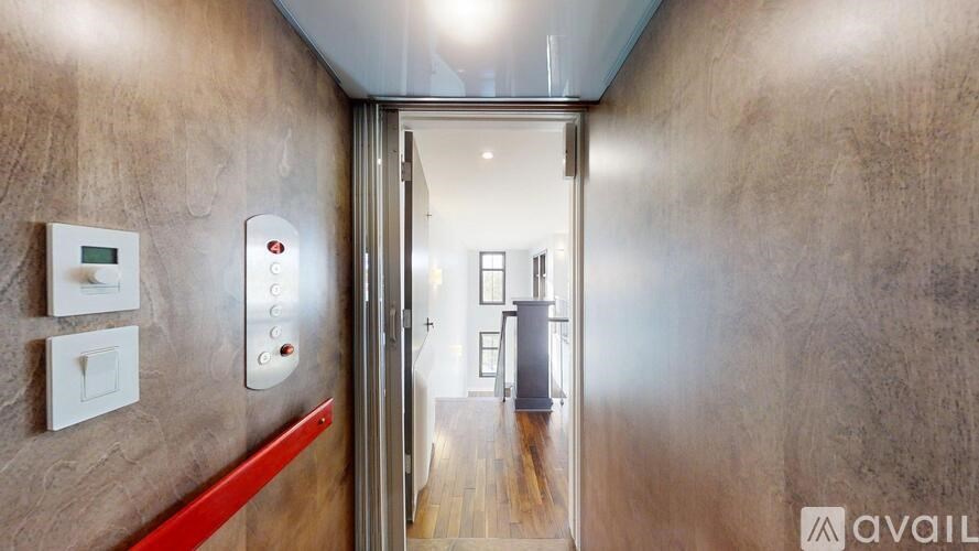 A hallway with a red line on the wall and a door at the end.