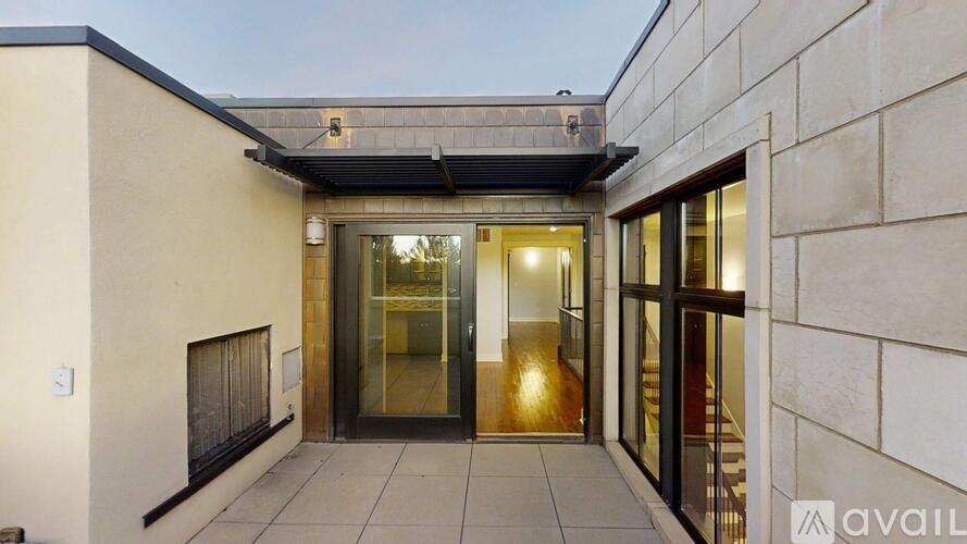 A modern house entrance with glass doors and a tiled floor.