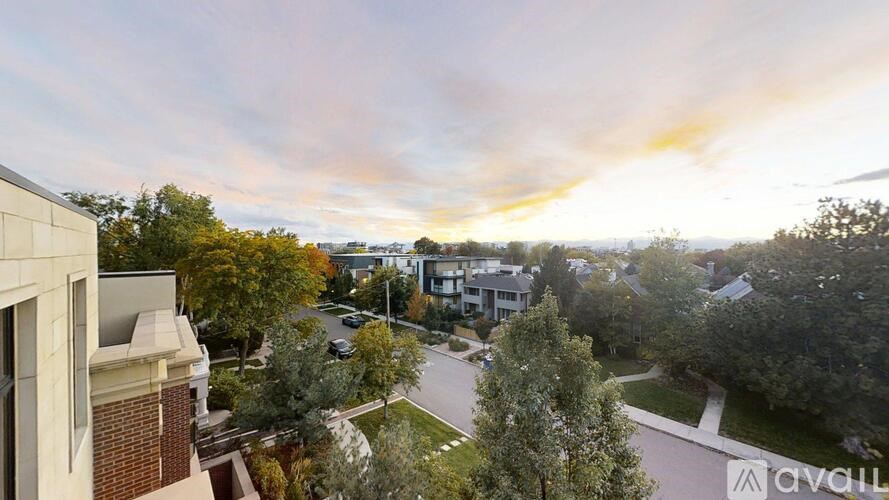 A view from a balcony overlooking a street with cars and houses.