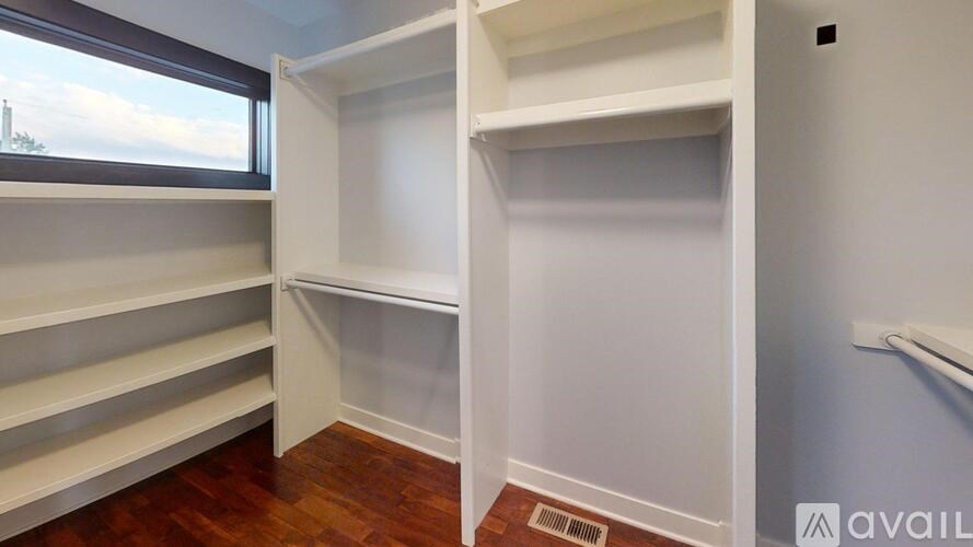 Empty white shelves in a room with a window.