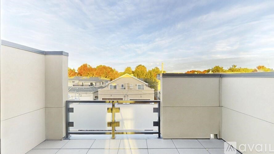 A balcony with a metal railing and a view of a residential area.