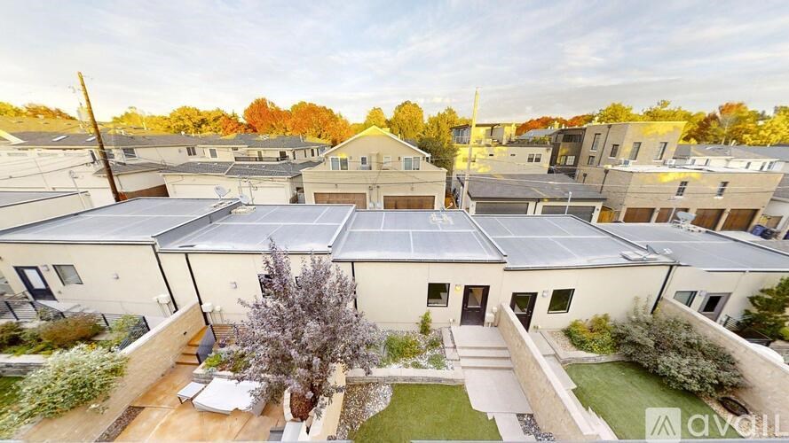 A house with solar panels on the roof is surrounded by other houses.