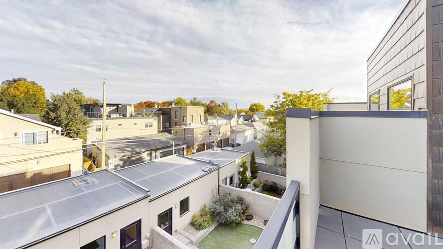 A view from a balcony overlooking a courtyard with a building on the right.