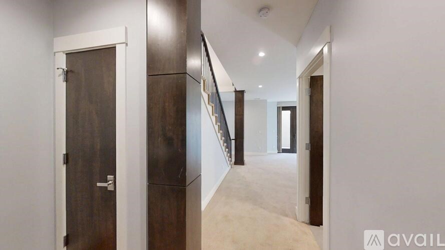 A hallway with a white door on the left and a brown door on the right.