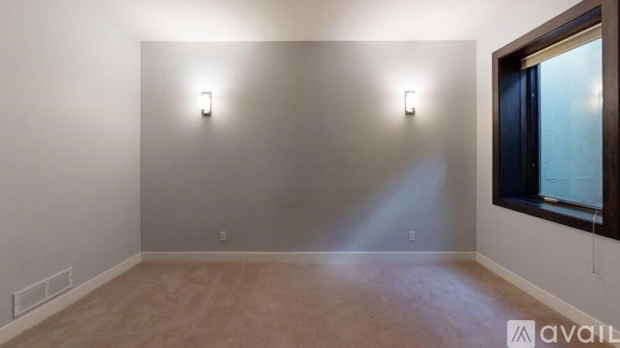 A room with a window and two lights on the wall.