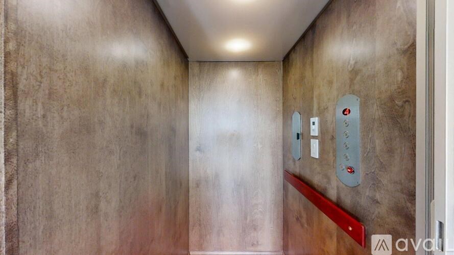 A hallway with a red line on the wall and three elevator buttons.