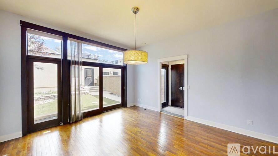 A room with wooden floors and a large window with a view of a snowy landscape.