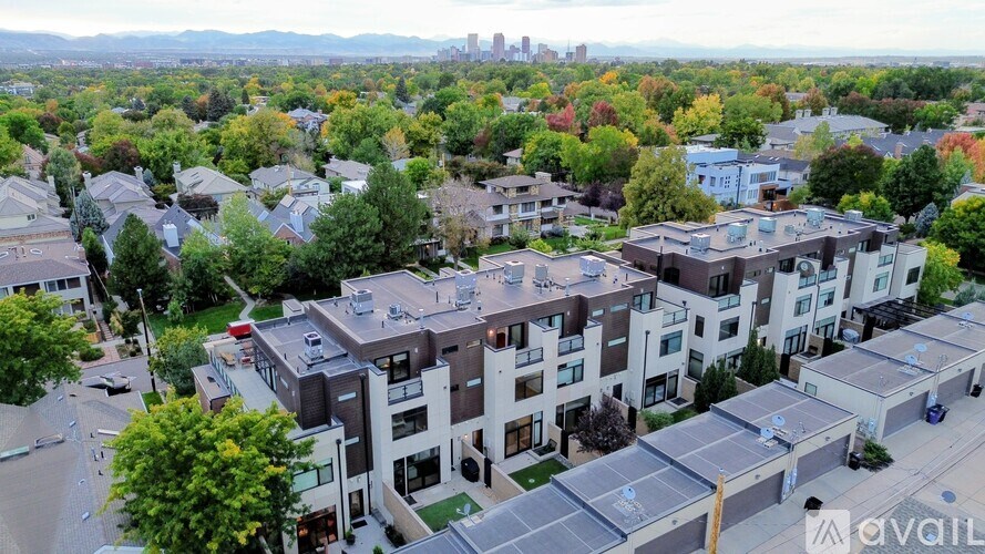A bird's eye view of a residential area with modern houses and cars parked on the streets.