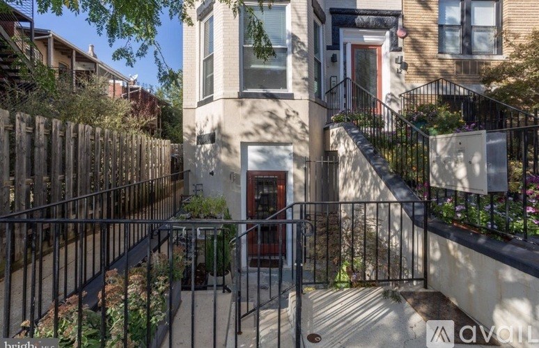 A house with a red door and a black fence.