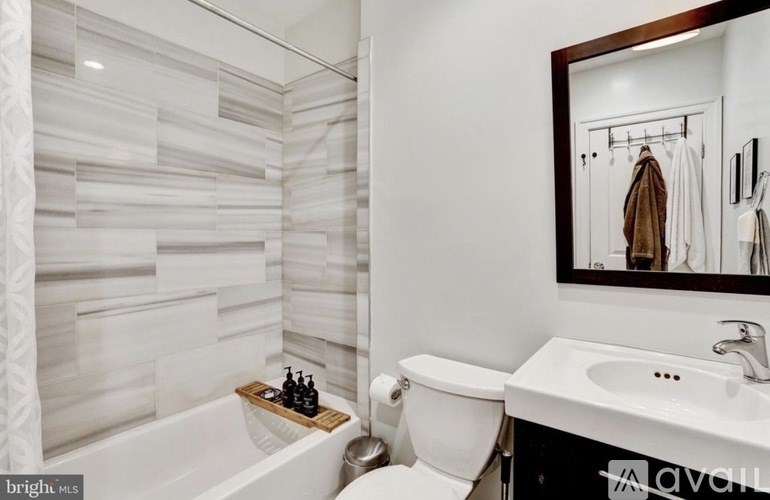 A white bathroom with a tub, toilet, and sink.