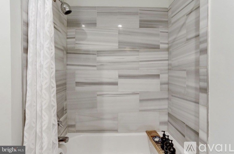 A white bathroom with a shower and a white curtain.