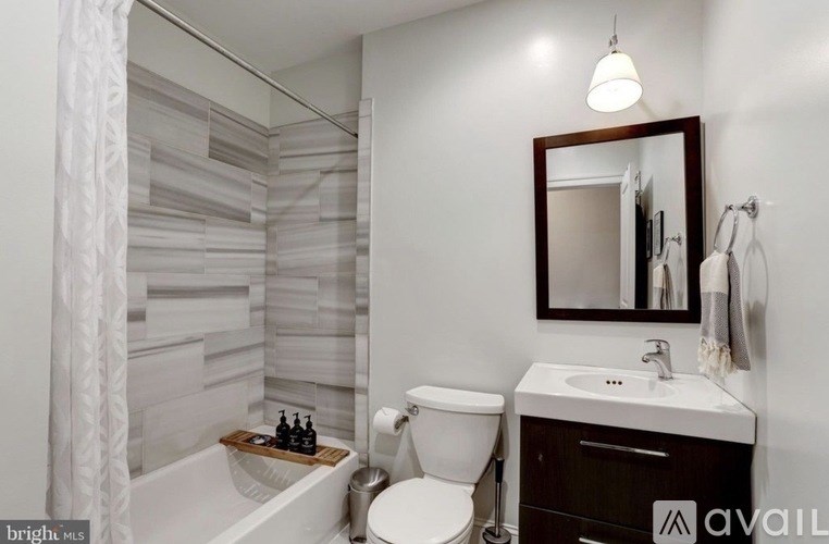 A bathroom with a white tub, toilet, and sink.