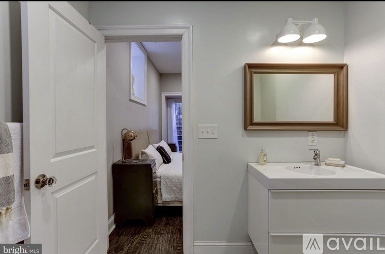A bathroom with a white sink and a mirror above it.