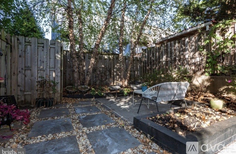 A backyard with a patio and a fence.