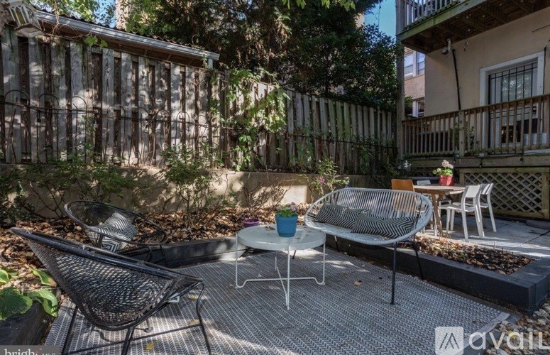 A patio with a table, chairs, and a bench.