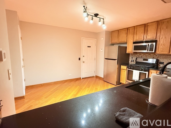 A kitchen with wooden cabinets and a black countertop.