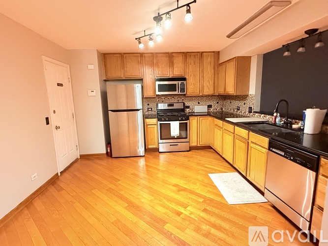 A kitchen with wooden cabinets and a stainless steel refrigerator.