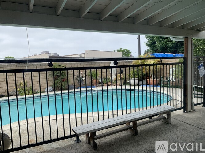 A pool with a bench and a fence.