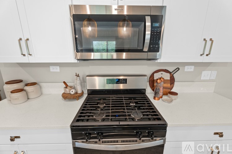 A modern kitchen with a stainless steel stove and microwave above it.