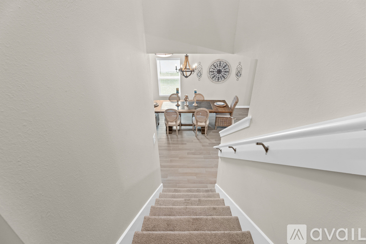 A hallway with a staircase leading to a dining area.