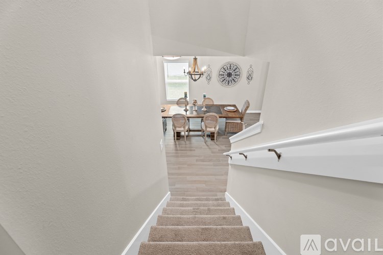 A hallway with a staircase leading to a dining area.