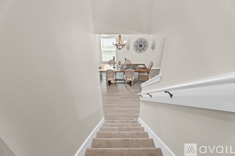 A hallway with a staircase leading to a dining area.