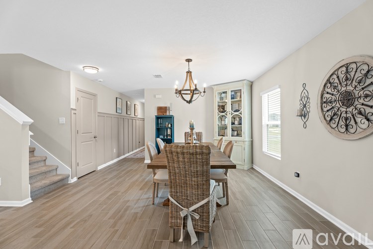 A dining room with a wooden table and chairs.