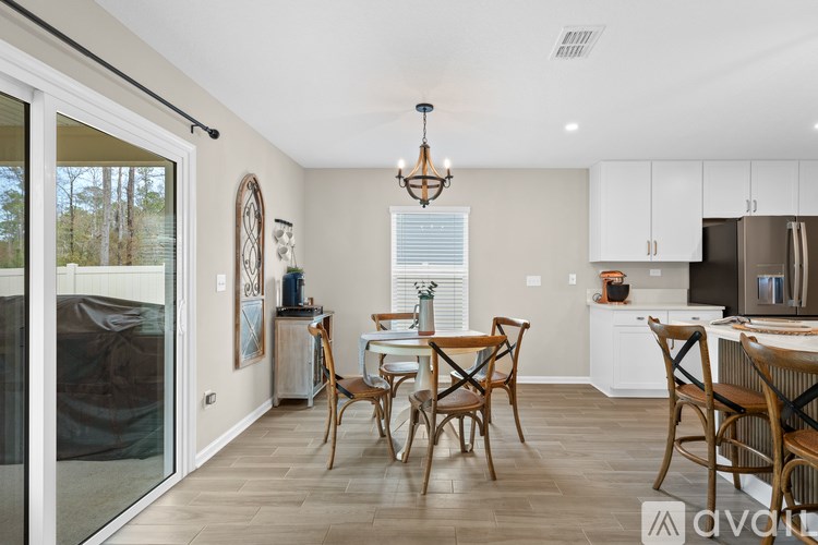 A dining room with a table set for two and a chandelier hanging from the ceiling.
