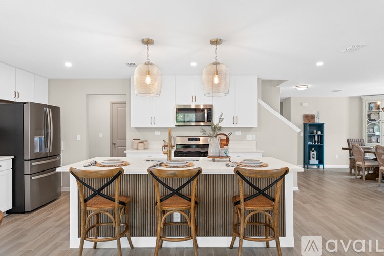 A modern kitchen with a large island and bar stools.