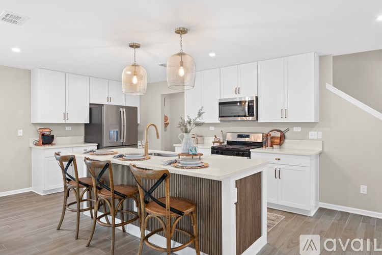 A kitchen with a center island and chairs.