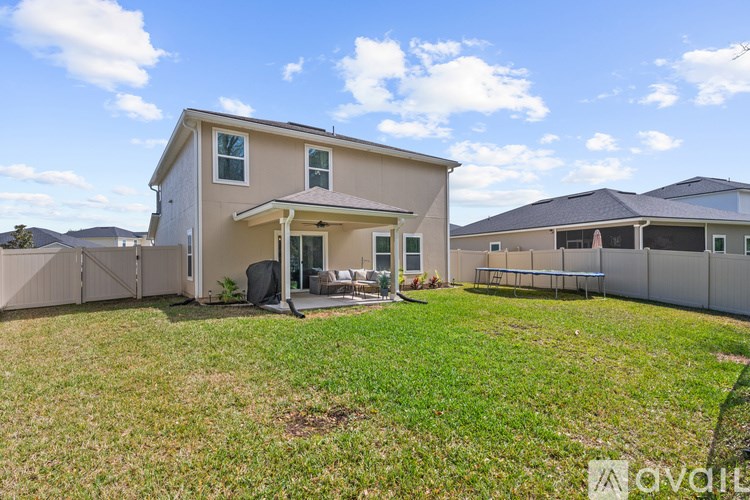 A house with a fenced backyard and a patio area.