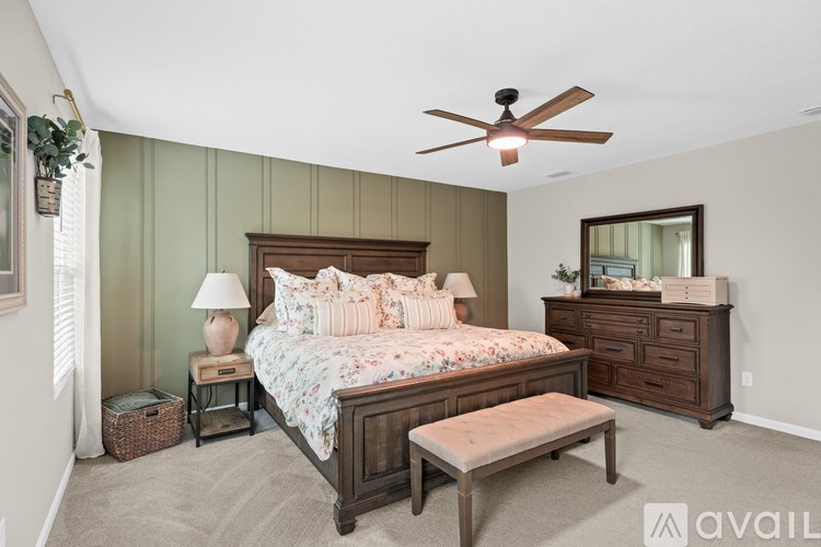 A bedroom with a bed, dresser, and a ceiling fan.