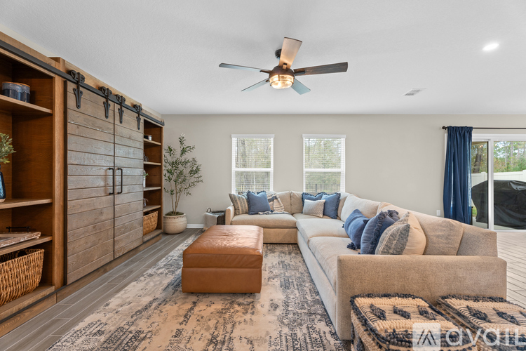 A living room with a brown rug and a white sofa.