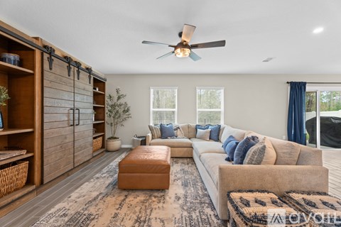 A living room with a brown rug and a white sofa.