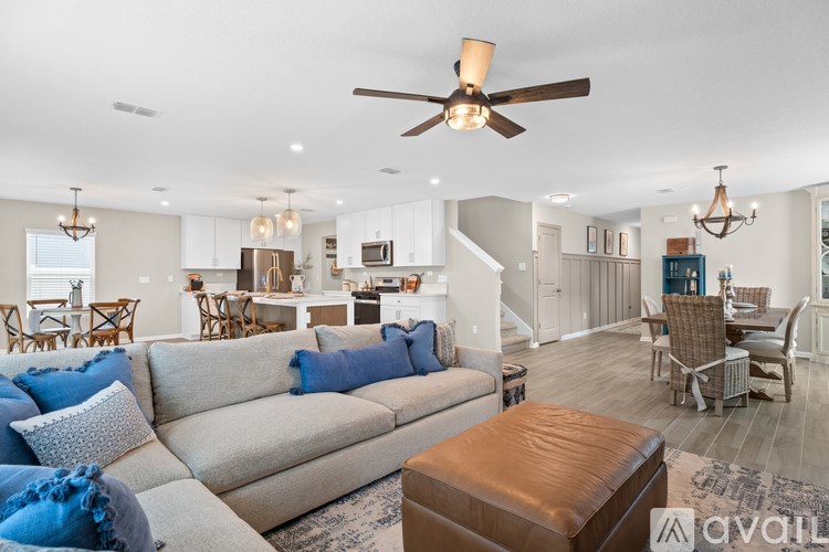 A living room with a beige couch and a brown ottoman.