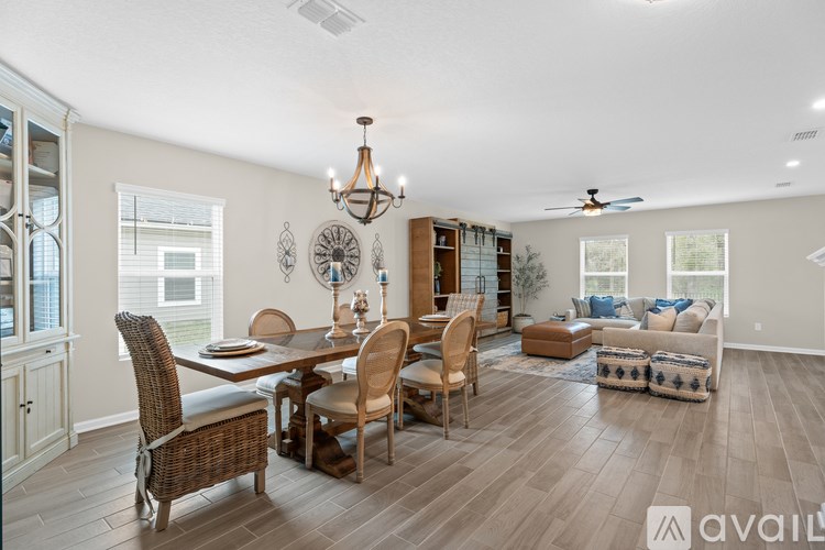 A well-lit, spacious dining area with a table set for six and a chandelier hanging from the ceiling.
