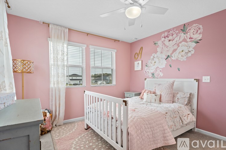 A baby's room with a white crib and a pink wallpaper.