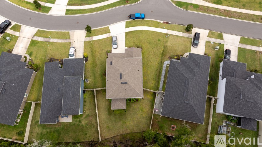 A car is driving on a road in a residential area.