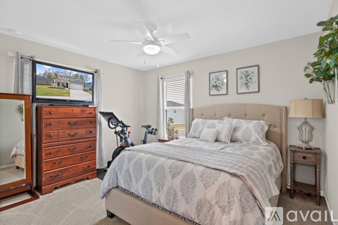 A bedroom with a large bed and a dresser with a mirror.