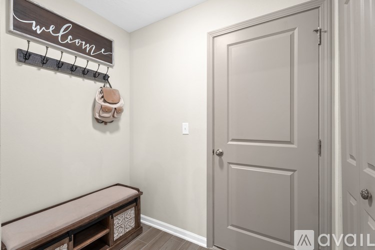 A hallway with a bench, a door, and a sign that says "welcome".