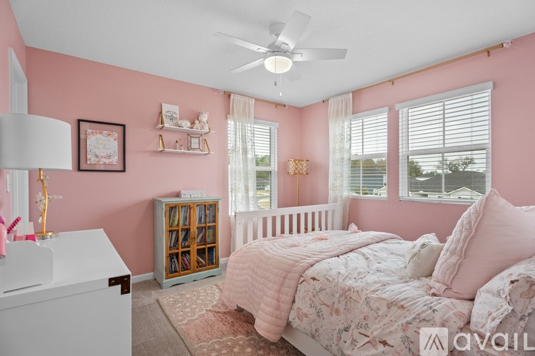 A bedroom with pink walls and a white bed.