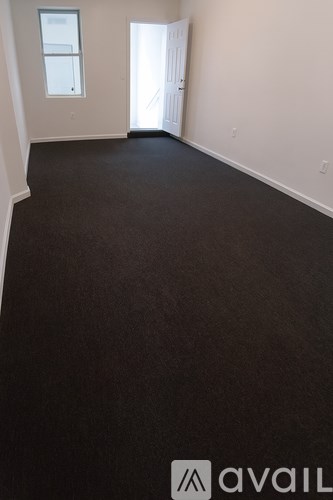 A room with a carpeted floor and a door.