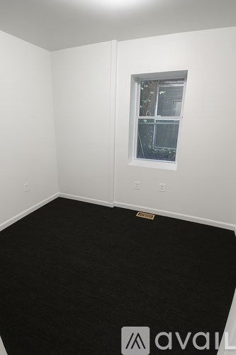 A room with a window and a black floor.