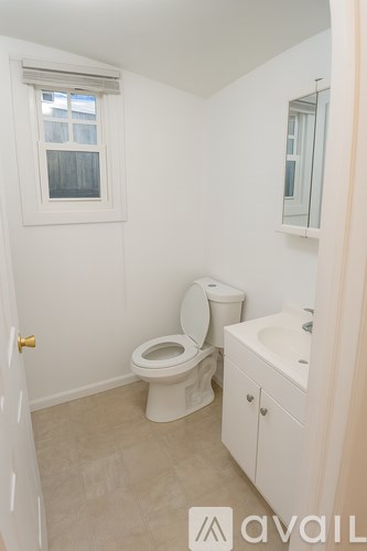 A small bathroom with a toilet, sink and window.
