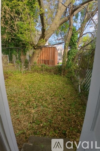 A backyard with a fence and a shed.