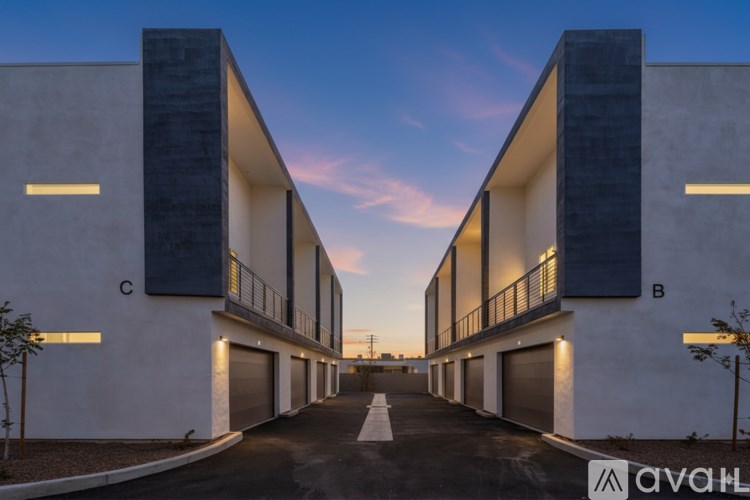 A modern building with the label 'C' on the left and 'B' on the right is illuminated by lights.