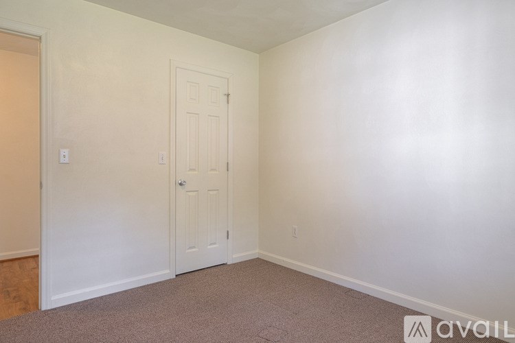 A room with a door and a wall socket.