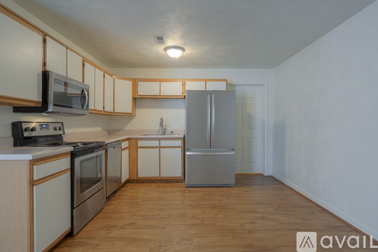 A kitchen with wooden floors and white walls.