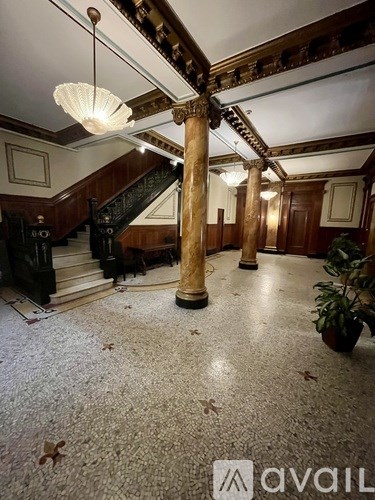 A hallway with a staircase and a plant.