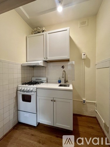 A kitchen with white appliances and cabinets.